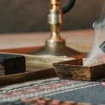 Closeup of hashish block with smoking hookah pipe and traditional fabric