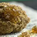 Moonrock cannabis concentrate covered in golden kief and hash oil, showcasing its rich texture and high potency.