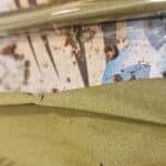 Close-up of green hemp blunt wrap and sealed blunt on a textured surface with herb pieces.