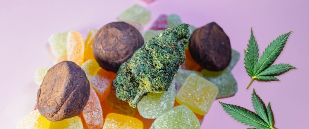 Assorted THC edibles, including gummies and chocolates, with a cannabis bud on a pink background.