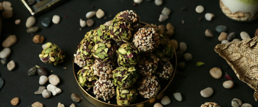 A bowl filled with cannabis-infused truffles coated in nuts