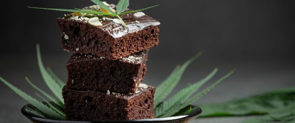 Three stacked cannabis-infused brownies topped with a cannabis leaf