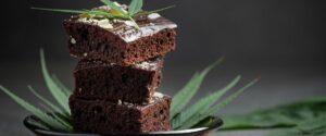 Three stacked cannabis-infused brownies topped with a cannabis leaf
