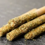 Kief-coated cannabis pre-rolls arranged on a flat surface.