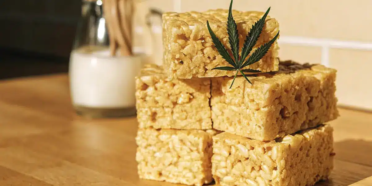 Brightly lit cannabis rice crispy edibles stacked with a cannabis leaf on top.