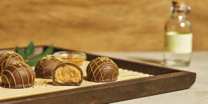 Close-up of cannabis chocolate truffles with rich peanut butter filling on a wooden tray