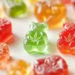 Colorful THC gummies in various shapes, including bears and cubes, with cannabis leaf icons embossed on some gummies