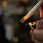 Close-up of how to light pre rolled weed with a lighter, showing proper technique for an even burn.