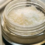 THCA isolate in a transparent jar with lab tools in the background.