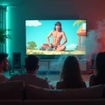A group of friends watching a cartoon on TV while smoking in a softly lit living room.