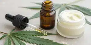 Close-up of cannabis oil and pain relief cream representing cannabis treatment for chronic pain.