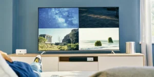 Person watching a TV showing four scenic landscapes, including stars, ruins, and the ocean.