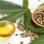 Close-up of CBD oil droplets and hemp seeds showing natural textures and vibrant details.