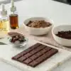 Realistic view of a kitchen countertop set up for a chocolate cannabis recipe with all required ingredients neatly arranged.