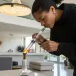 Realistic image of a person dabbing concentrate using a modern rig, demonstrating proper technique for effective concentrate use.