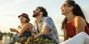 Realistic image of friends enjoying best strains for laughing, showing vibrant smiles and relaxed outdoor ambiance.