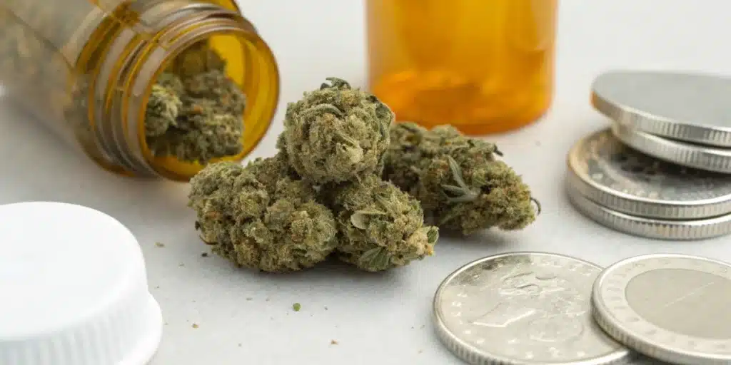 Realistic close-up of cannabis buds with coins and containers used as references to estimate weight without a scale.