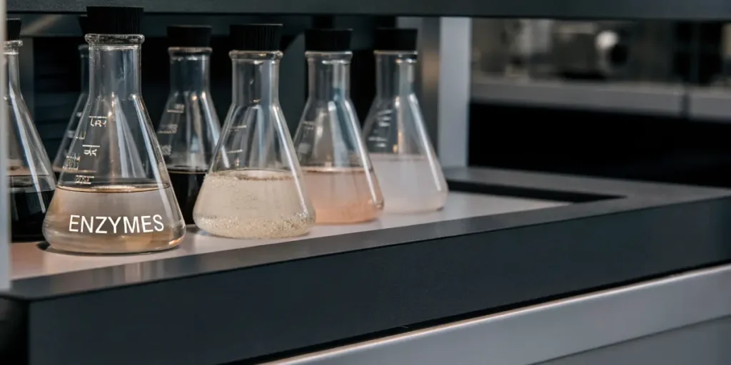 Flasks with cannabis enzyme extracts on a modern laboratory bench.