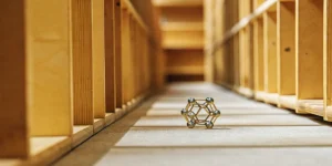Metallic cannabis molecular structure model displayed on wooden floor.