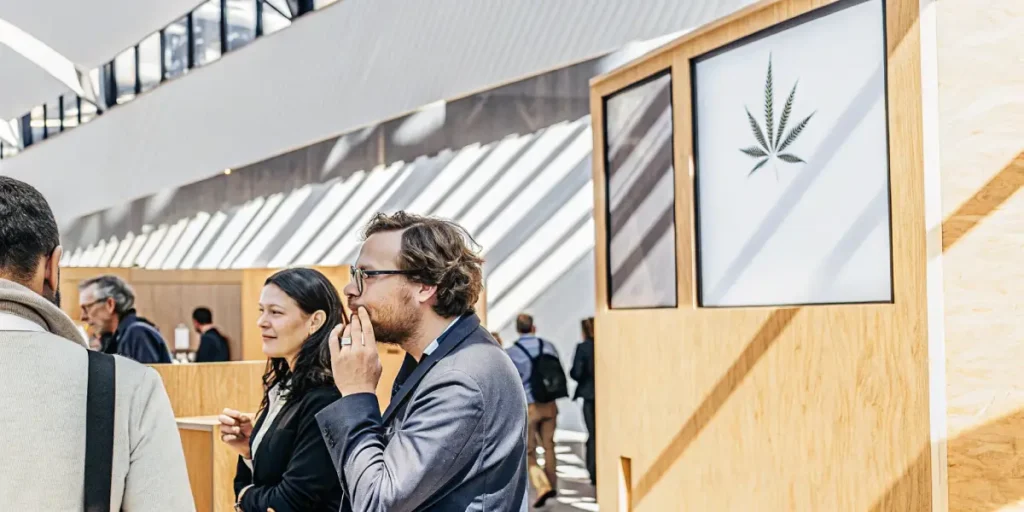 Professionals discussing products at a modern cannabis business expo booth.