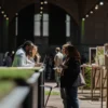 Visitors networking and exploring cannabis product displays at a large industry exhibition.