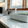 Smart indoor garden planter with LED grow light on a bright marble kitchen countertop.